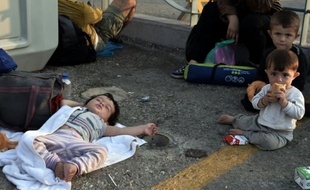 Des enfants dorment sur le sol, le 16 août 2015 au port de Kos après avoir débarqué en provenance de Syrie
