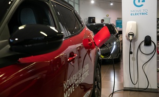 Un véhicule électrique branché sur une prise (Illustration).