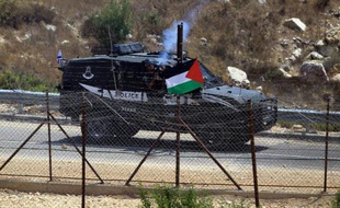 Un membre des forces de sécurité israéliennes tire des gaz lacrymogènes contre des manifestants palestiniens à Nafez le 2 août 2014
