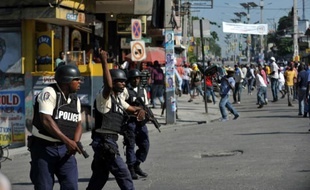 Un policier tire en l'air lors de heurts avec des manifestants, le 24 novembre 2015 à Port-au-Prince, en Haïti
