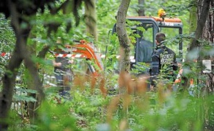 Les policiers ont creusé à l'endroit où ont été retrouvées des parties de corps dans le bois.