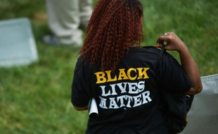 Une femme porte un t-shirt "Black Lives Matter" pendant un hommage rendu à Michael Brown, le 9 août 2015 à Ferguson