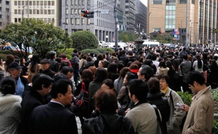 Des personnes patientent dans les rue du quartier d'affaires de Tokyo après avoir été évacuées, le 11 mars 2011.