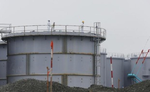 Des employés travaillent sur une citerne contenant de l'eau contaminée à la centrale nucléaire de Fukushima Daiichi au Japon, le 12 novembre 2014