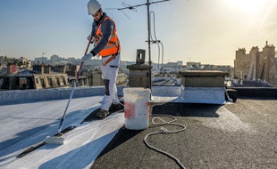 Pose de la peinture blanche mise au point par Cool Roof sur un toit de Paris.