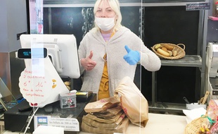 Boulangère derrière un hygiaphone conçu par Orsteel Light, lors de la pandémie de coronavirus