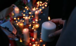 Scènes de recueillement le 15 novembre 2015 à Paris après la série d'attentats qui a fait au moins 129 morts. Des anonymes déposent fleurs, bougies et dessins devant Le Carillon, et sur la Place de la République.