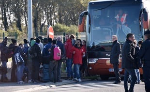 Des associations accompagnent de jeune migrants vers un bus qui va quitter Calais vendredi 28 octobre.