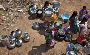 Des femmes rassemblent des sceaux pour collecter l'eau à une fontaine public dans la banlieue d'Hyderabad, en Inde.