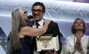Le réalisateur turc Nuri Bilge Ceylan (c) félicité par la présidente du jury, Jane Campion, après avoir reçu la palme d'Or au 67e festival de Cannes le 24 mai 2014
