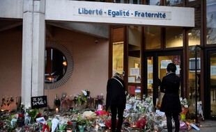 De très nombreuses fleurs ont été déposées en hommage à Samuel Paty devant son collège de Conflans.