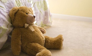 Un ours en peluche dans une chambre d'enfant.
