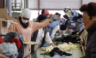 Des femmes travaillent, le 24 février 2010, à Chanteloup-les-Vignes, dans les Yvelines, au centre de tri et de recyclage de vêtements de l'association Le Relais