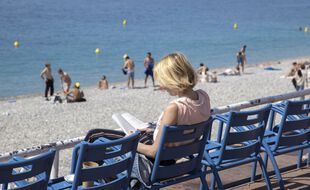 Une femme lit sur la Promenade des Anglais à Nice