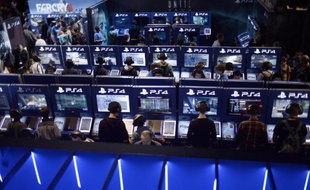 Des visiteurs du salon des jeux en ligne à Paris testent la PlayStation 4 le 29 octobre 2014
