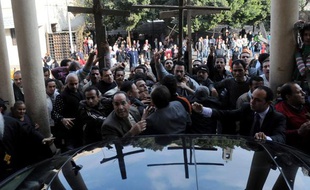 Des chrétiens d'Egypte manifestent autour de la voiture du grand Imam d'Al-Azhar, Ahmed al-Tayeb, venus présenter ses condoléances au patriarche copte orthodoxe Chenouda III, au Caire, le 2 janvier 2011.