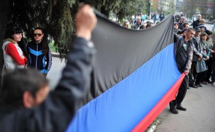 Des pro-russes brandissent un drapeau de l'autoproclamée "République de Donetsk" lors d'un rassemblement séparatiste, le 18 avril 2014 à Slaviansk, en Ukraine