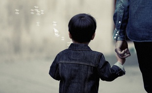 Un petit garçon et un de ses parents.
