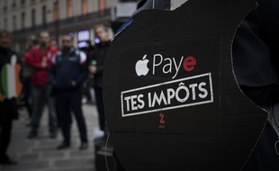Un membre d'Attac manifeste contre l'évasion fiscale devant un magasin Apple en novembre 2017.