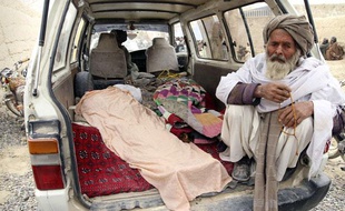 Un Afghan se tient à proximité des corps de victimes de la tuerie, le 11 mars 2012