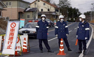 Policiers barrant une route d'accès à un élevage de poulets contaminé par la grippe aviaire, à Tanba près de Kyoto en mars 2004