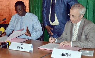 Luc Oursel, le président du directoire d'Areva (d) et Omar Hamidou Tchiana, le ministre nigérien des Mines, signent un accord sur les mines d'uranium le 26 mai 2014 à Niamey