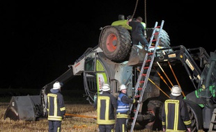 Des pompiers près de la pelleteuse qui a basculé en Allemagne, tuant un jeune homme et blessant cinq autres personnes lors d'un défi lancé sur Facebook, le 29 juillet 2014.