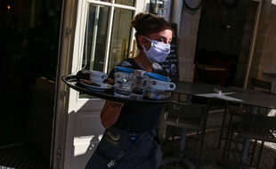 Une serveuse porte un masque de protection sur la terrasse d un café au port de Vannes.