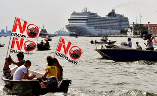 Des militants environnementaux brandissent des banderoles «Non aux navires de croisière» à bord de petites embarcations à moteur dans la lagune de Venise, alors que le MSC Orchestra quitte Venise, le 5 juin 2021.