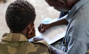 Un ancien enfant-soldat est pris en charge par un membre de l'UNICEF le 27 mai 2013 à Bangui