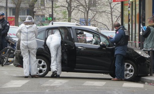 Rue de Meaux (19e), la voiture laissÈe au travers de la route par les auteurs de la fusillade de Charlie Hebdo est scrutÈe de prËs par des enquÍteurs de la police scientifique et judiciaire.
