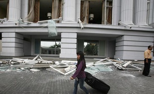 Une cliente quitte le Ritz-Carlton de Jakarta après le double attentat qui a fait neuf morts le 17 juillet 2009.