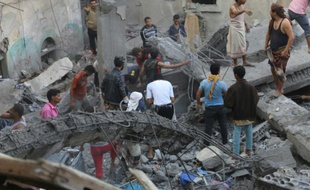 Des voisins inspectent les décombres d'une maison détruite par des frappes d'Arabie saoudite, le 1er novembre 2015 dans la ville de Taez