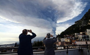 Des badauds prennent des photos de l'Etna en éruption, le 4 décembre 2015 à Taormina en Sicile