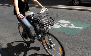 Une femme roule en Vélib', à Paris, le 20 juillet 2009.