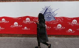 Une femme passe à côté d'une fresque anti-américaine sur l'ancien bâtiment de l'ambassade américaine à Téhéran (Iran)
