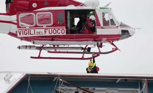 Un hélicoptère survole l'épave du navire de croisière Costa Concordia, le 16 janvier 2012, au large de la Toscane.