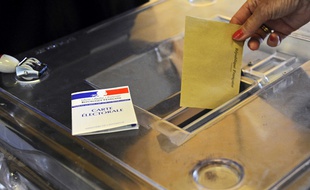 Illustration: Une personne glisse son bulletin dans une urne, lors des élections législatives de 2012, à Arles.