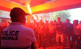 Des employés de la SNCM face à un policier lors d'une manifestation à Marseille, le 30 juin 2014