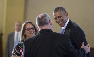 Le président américain Barack Obama (d) parle au père Juan Rumin Dominguez (de dos) pendant sa visite du sanctuaire de Notre-Dame de la Charité à Miami, le 28 mai 2015