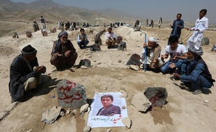Des villageois en pleine prière devant les tombes des victimes du double attentat perpétré samedi 23 juillet 2016 à Kaboul.