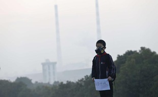 Un jeune villageois de la province de Zhejiang (Chine) porte une pancarte lors d'une manifestation contre la pollution le 19 mars 2013, sur laquelle est écrit «Je veux respirer».