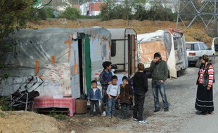 Les membres de deux familles de Roms dont les caravanes ont été évacuées d'un champ qu'ils occupaient, près de Nantes, le 25 mars 2011.
