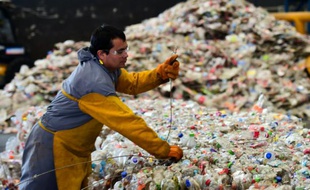 Un employé rassemble des bouteilles en plastique sur le site d'une usine de recyclage à Toluca dans l'état de Mexico le 27 avril 2016