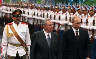 Le président russe Vladimir Poutine (d) reçu à Cuba par son homologue cubain Raul Castro (c) Place de la Révolution à La Havane le 11 juillet 2014