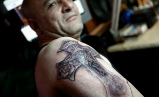 Un tatouage montrant Jésus Christ sur la Croix dessiné sur le bras d'un Egyptien copte par le tatoueur palestinien Walid Ayash dans son studio de Bethléem en Cisjordanie le 28 avril 2016