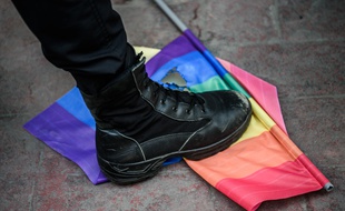 Un policier turc marche sur un drapeau arc-en-ciel de la «trans pride», à Istanbul le 19 juin 2016.