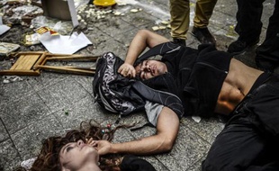 Des manifestants blessés sont à terre alors que la police turque a employé canons à eau et gaz lacrymos pour les disperser, près de la place Taksim à Istanbul, le 31 mai 2014