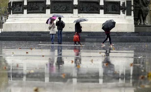 Des personnes marchent sous la pluie le 9 novembre 2013.