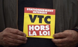 Un chauffeur de taxi parisien proteste contre le géant américain du VTC Uber, le 15 décembre 2014 à Roissy, en région parisienne